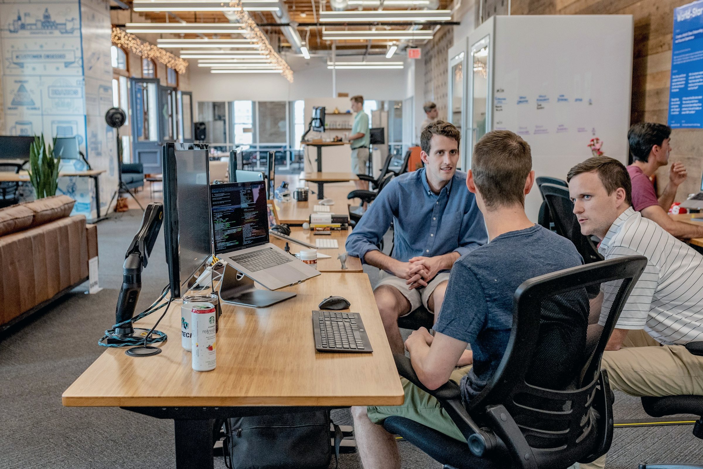Colleagues working together at a long shared desk in a bright open-plan office