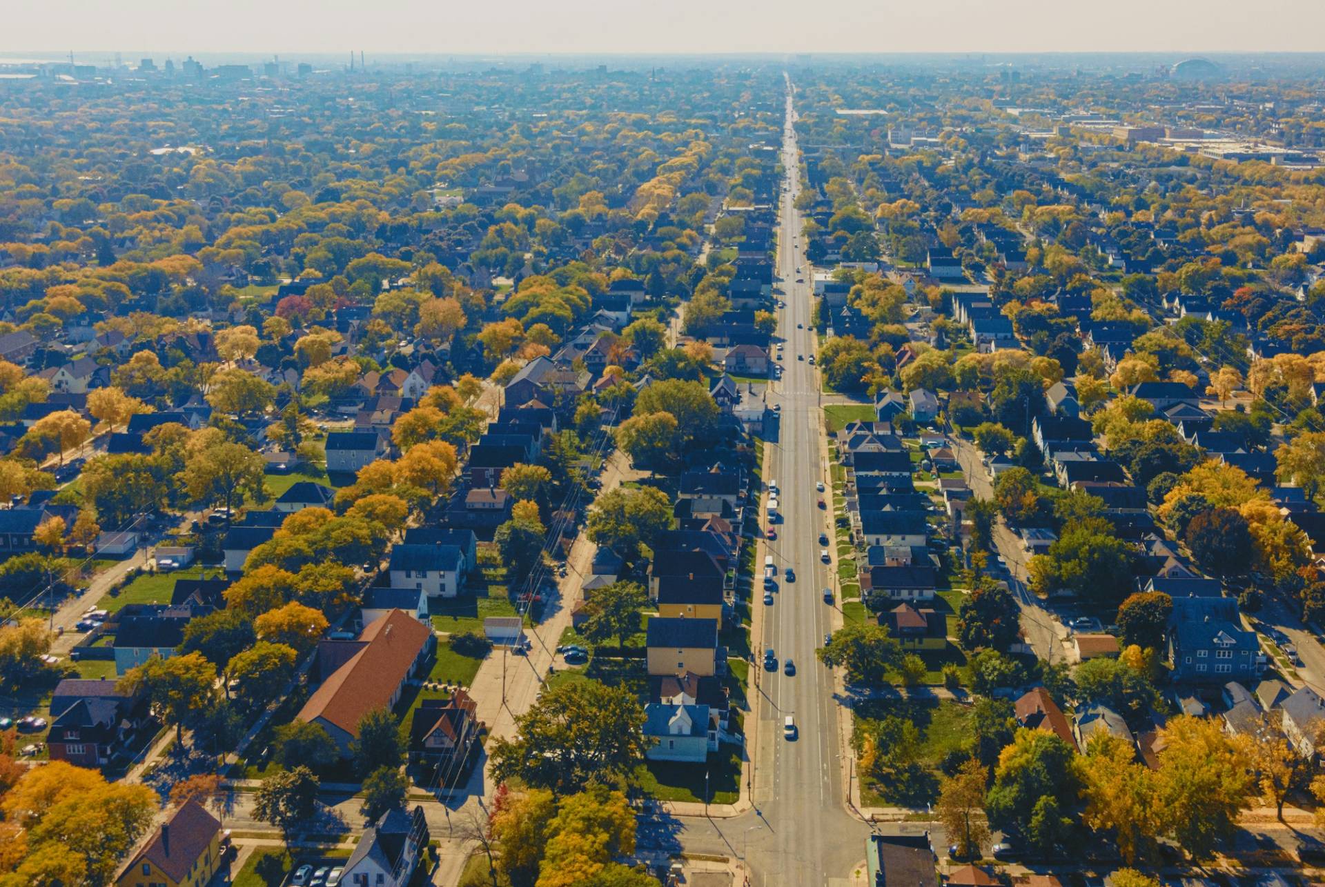Aerial view of a tree-lined American town in autumn, a main street running toward the horizon